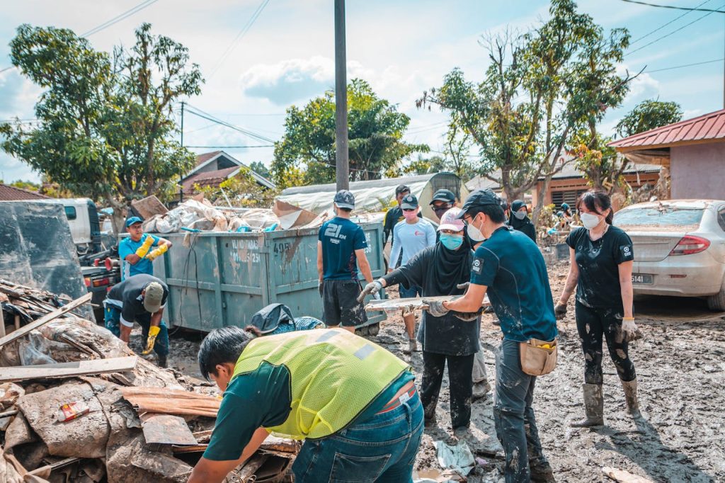 group-of-people-cleaning-together-12091690 Volunteers work together to clean up debris after a natural disaster, showcasing community effort and teamwork.
