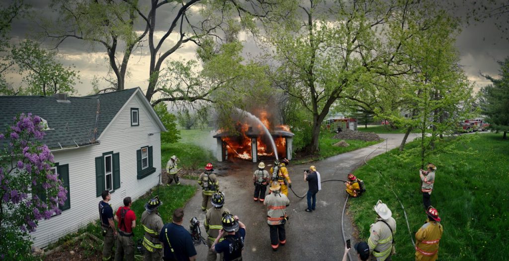 squad-extinguishing-a-burning-garage-and-a-group-of-watching-firefighters-16931871 A team of firefighters training to extinguish a burning garage in Racine, WI.